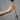 Frauenhand mit dem Circle Armreif und zwei Ringen der Kollektion am selben Finger, hält eine Blume.